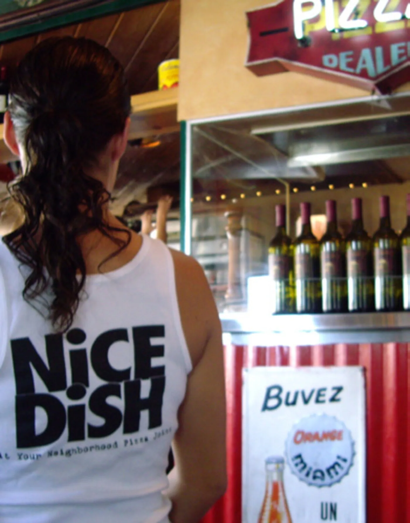 Oregano's bottle wall — branded house wines and 'Nice Dish' staff t-shirts